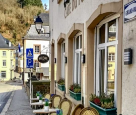 Foto van de Grand Rue in Vianden. De foto toont het terras van Café du Pont. Met rechts de voorgevel van Café Du Pont en links in de verte de brug over rivier de Our. Deze foto is zowaar een keer niet gemaakt door Marcel de Hoog, maar door de uitbater van het café.
